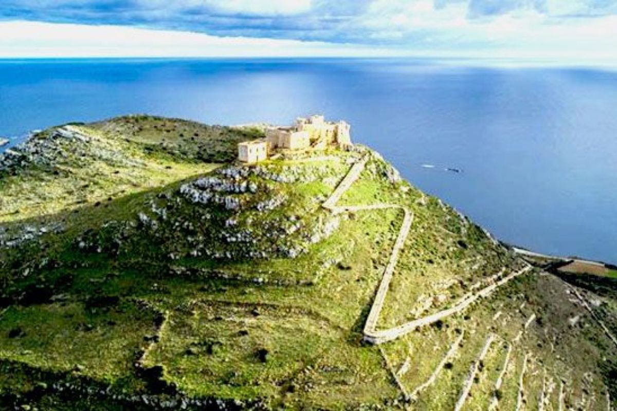 Panorama dall’alto di Favignana con sentieri, vegetazione mediterranea e il Castello di Santa Caterina in evidenza